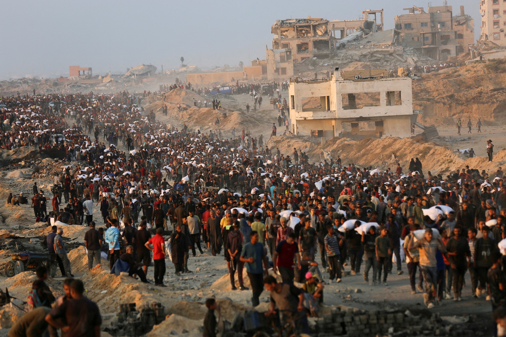 Palestinos se reúnem para receber suprimentos de ajuda em Beit Lahia, no norte da Faixa de Gaza, em 17 de junho de 2025. (Foto: REUTERS/Stringer)