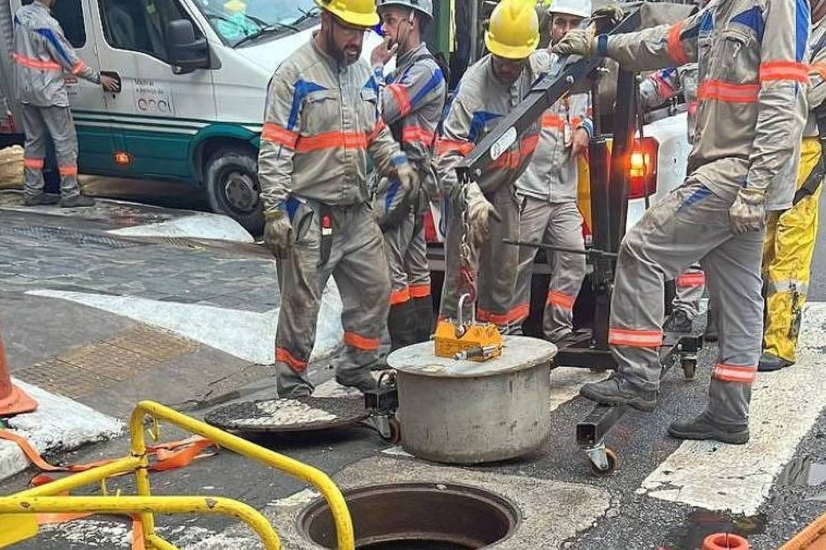 Furtos de cabos diminuem, mas 10 mil imóveis seguem sem luz na Grande SP Funcionários da Enel manipulam tampa de concreto de caixa subterrânea de energia com ajuda de guindaste (Foto: Divulgação/Enel)