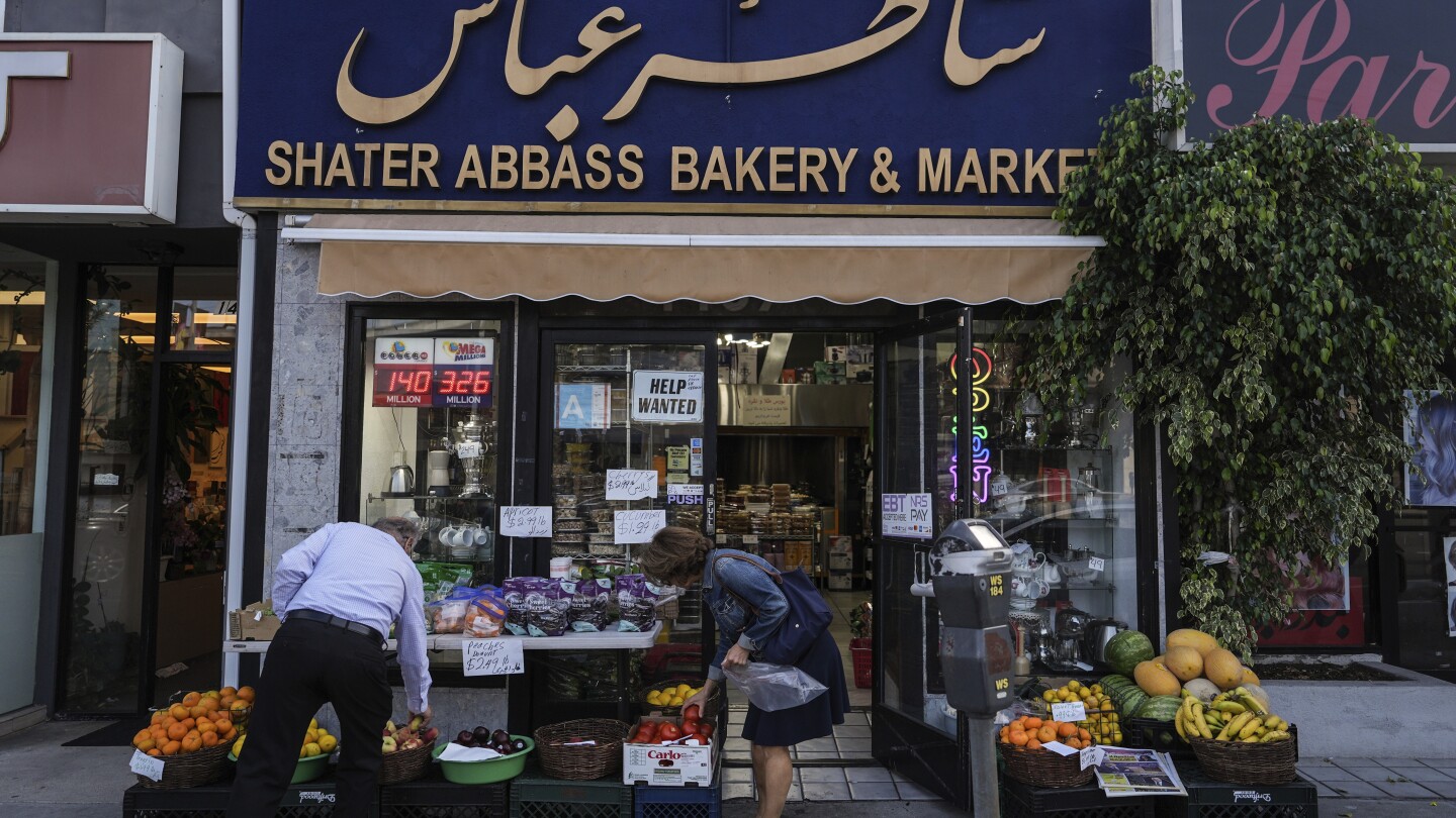 Dois compradores selecionam itens em um supermercado no bairro "Tehrangeles" de Los Angeles na terça-feira, 24 de junho de 2025. (Foto: AP Photo/Jae C. Hong)
