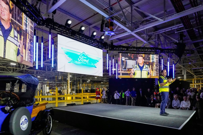 Jim Farley, CEO da Ford, fala em um palco ladeado por três telas na Louisville Assembly Plant (Foto: AP Photo/Darron Cummings)