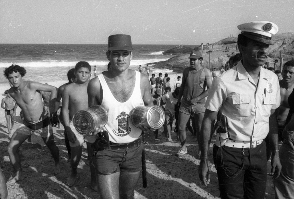 Milhares de latas de maconha são encontradas nas praias do Rio de Janeiro Policial com latas cheias de maconha saindo da praia de Ipanema (Foto: Lucio Marreiro/Agência O GLOBO)