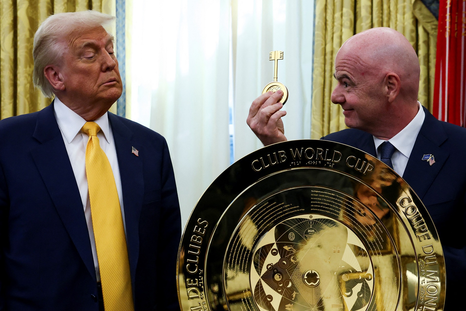 O presidente da FIFA, Gianni Infantino, segura a chave do troféu da Copa do Mundo de Clubes da FIFA ao lado do presidente dos EUA, Donald Trump, no Salão Oval da Casa Branca em Washington, D.C., EUA, 7 de março de 2025. (Foto: REUTERS/Evelyn Hockstein)