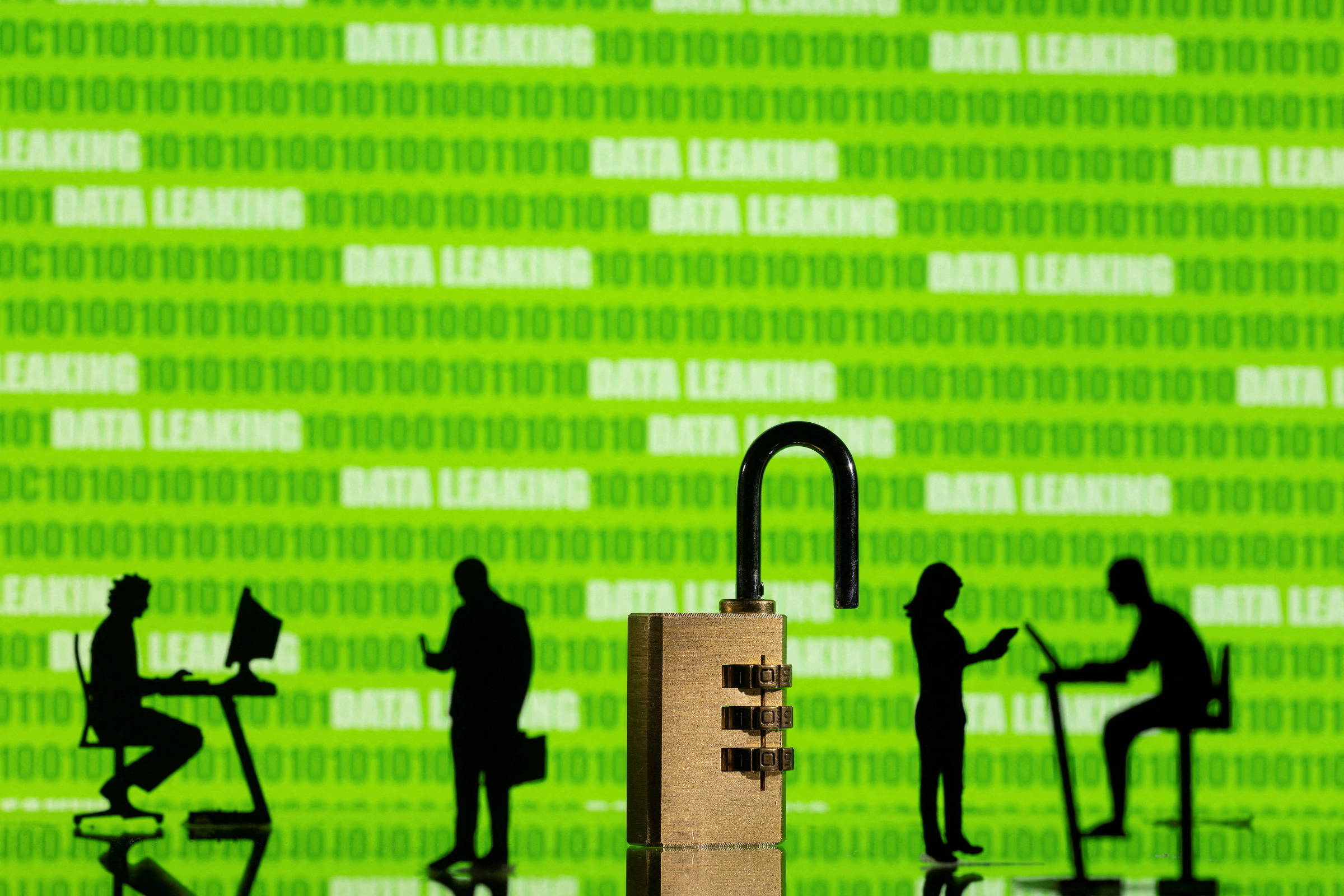 Hacker desvia R$ 541 milhões da BMP em 100 operações para 29 instituições financeiras Silhuetas de bonecos em ambiente corporativo, à frente de códigos de programação e ao lado de um cadeado destrancado (Foto: Dado Ruvic/Reuters)