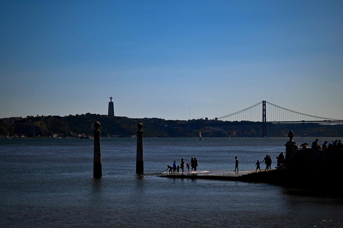 Portugal registra 69 mortes a mais devido à onda de calor na Europa Pessoas caminham pelo Cais das Colunas, na margem do Rio Tejo, em Lisboa (Foto: Patrícia de Melo Moreira/AFP/Agosto-2023)