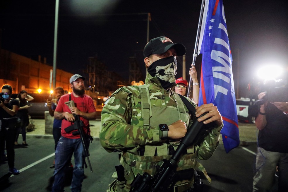 Megaprojeto de Trump fortalece lobby das armas e gera polêmica nacional Apoiadores do presidente dos EUA, Donald Trump, com rifles semiautomáticos durante encontro no Arizona (Foto: Jim Urquhart/Reuters)