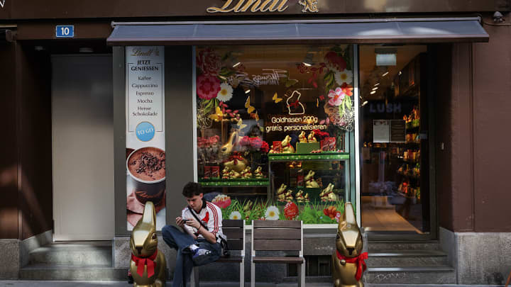 Uma pessoa senta-se em frente à loja de Chocolates Lindt em 11 de abril de 2025 em Basel, Suíça. (Foto: Sedat Suna | Getty Images News | Getty Images)