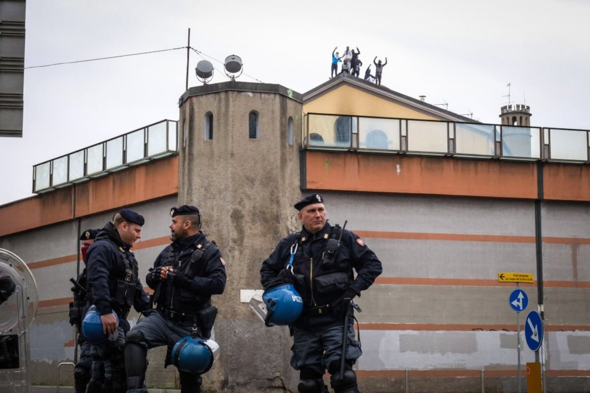 Itália planeja soltar 10 mil presos para combater superlotação nas prisões Policiais italianos em frente à prisão de San Vittore, enquanto se vê atrás os detidos protestando no telhado da prisão em Milão (Itália), em 2020. (Foto: EFE)