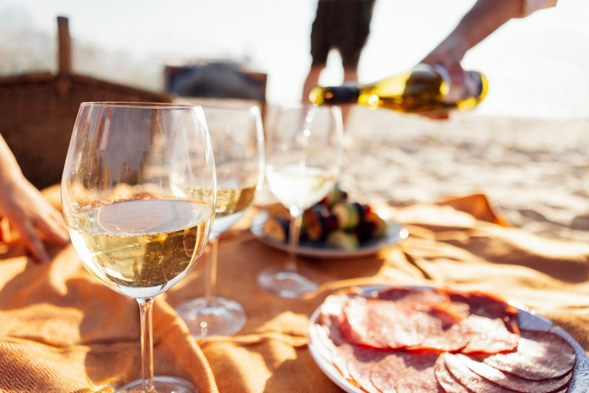 Uma imagem de prazer estival: servindo um vinho espumoso, em pleno pícnic playero. (Foto: Darya Petrenko / Alamy / Cordon Press)