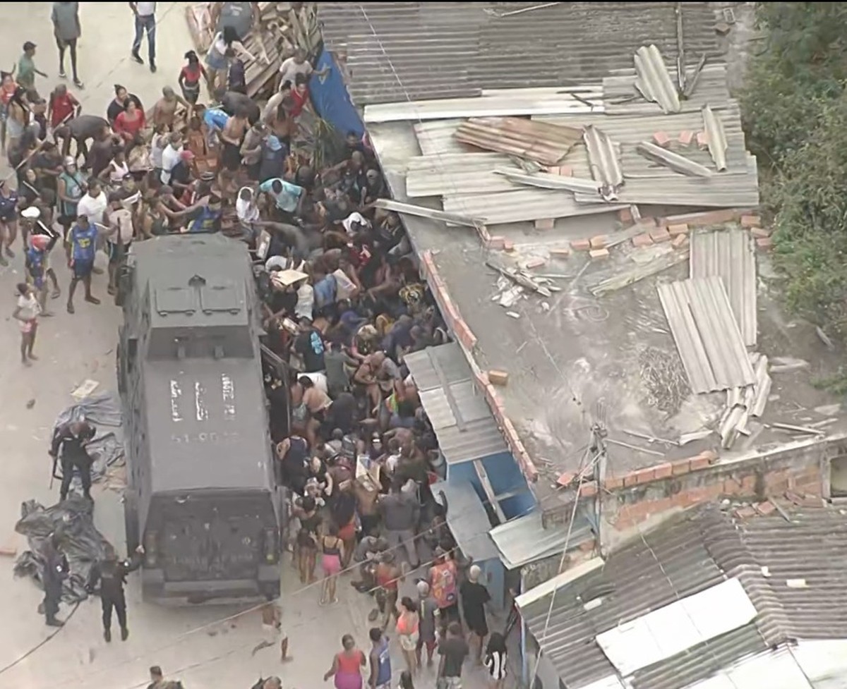 Pessoas saqueiam carga de carne no Complexo da Pedreira, e blindado da PM é cercado (Foto: Reprodução / TV Globo)