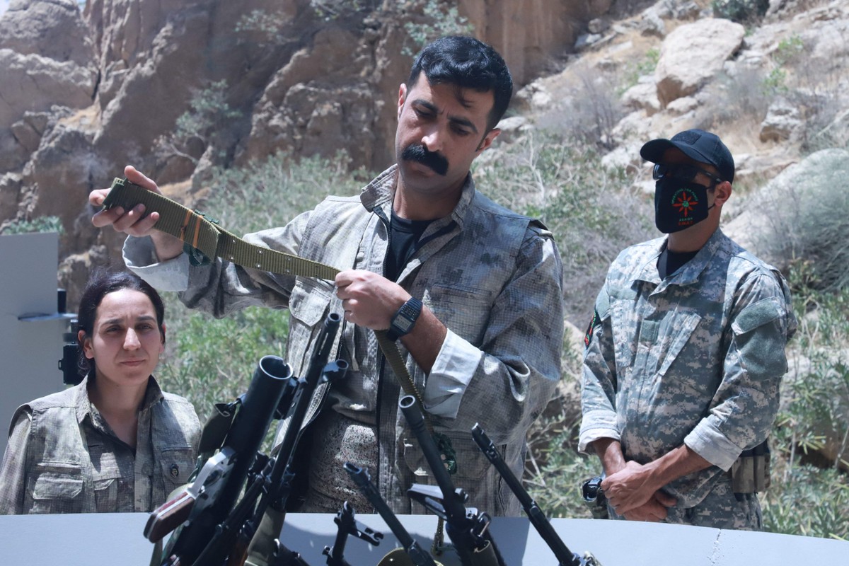 Curdos do PKK destroem armas em cerimônia no Iraque, marcando avanço na paz Combatentes curdos depõem as armas em cerimônia no Curdistão iraquiano (Foto: Shwan Mohammed/AFP)