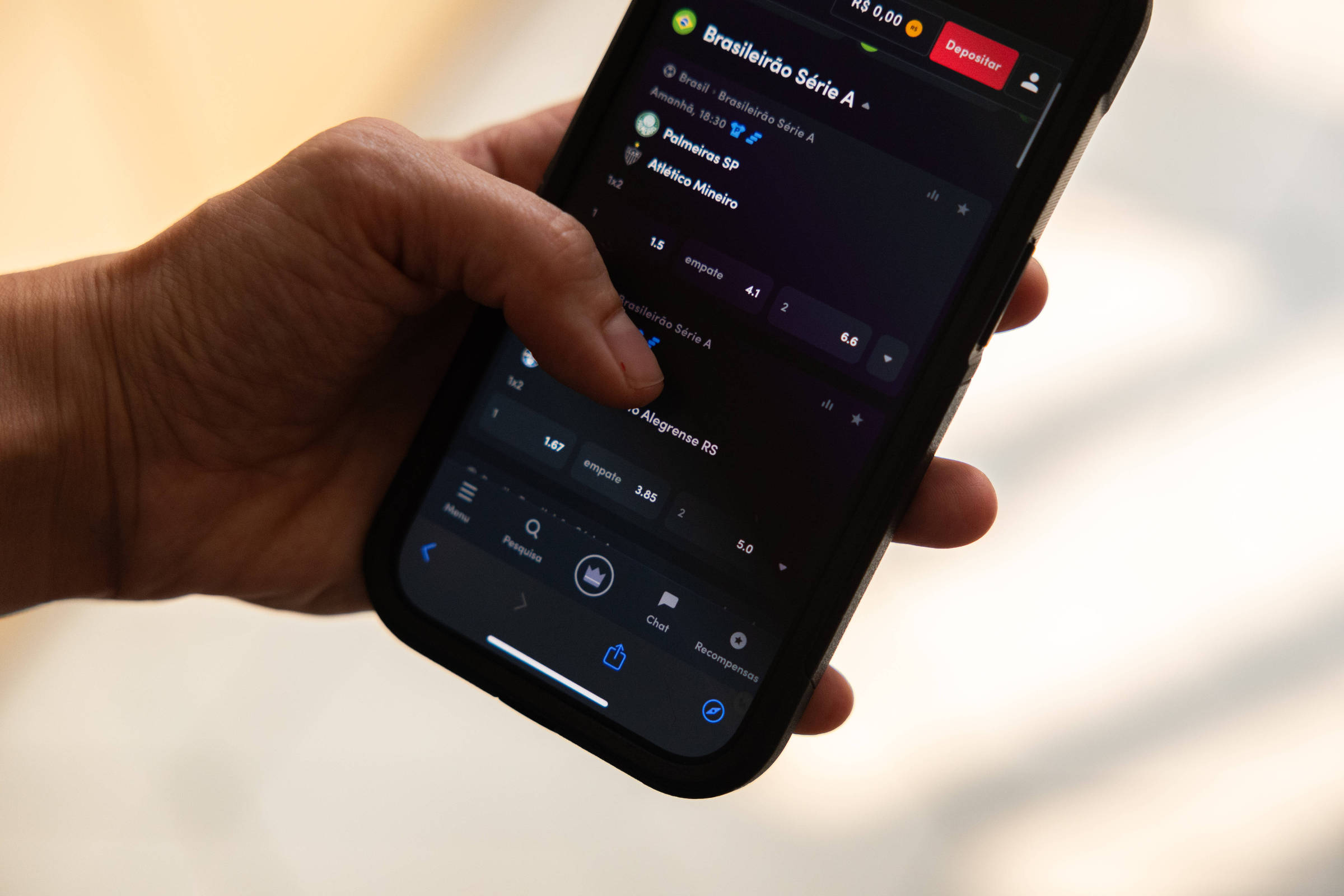 Justiça determina que casas de apostas informem sobre restrição do Bolsa Família Celular conectado em site de aposta (Foto: Danilo Verpa - 27.set.2024/Folhapress)