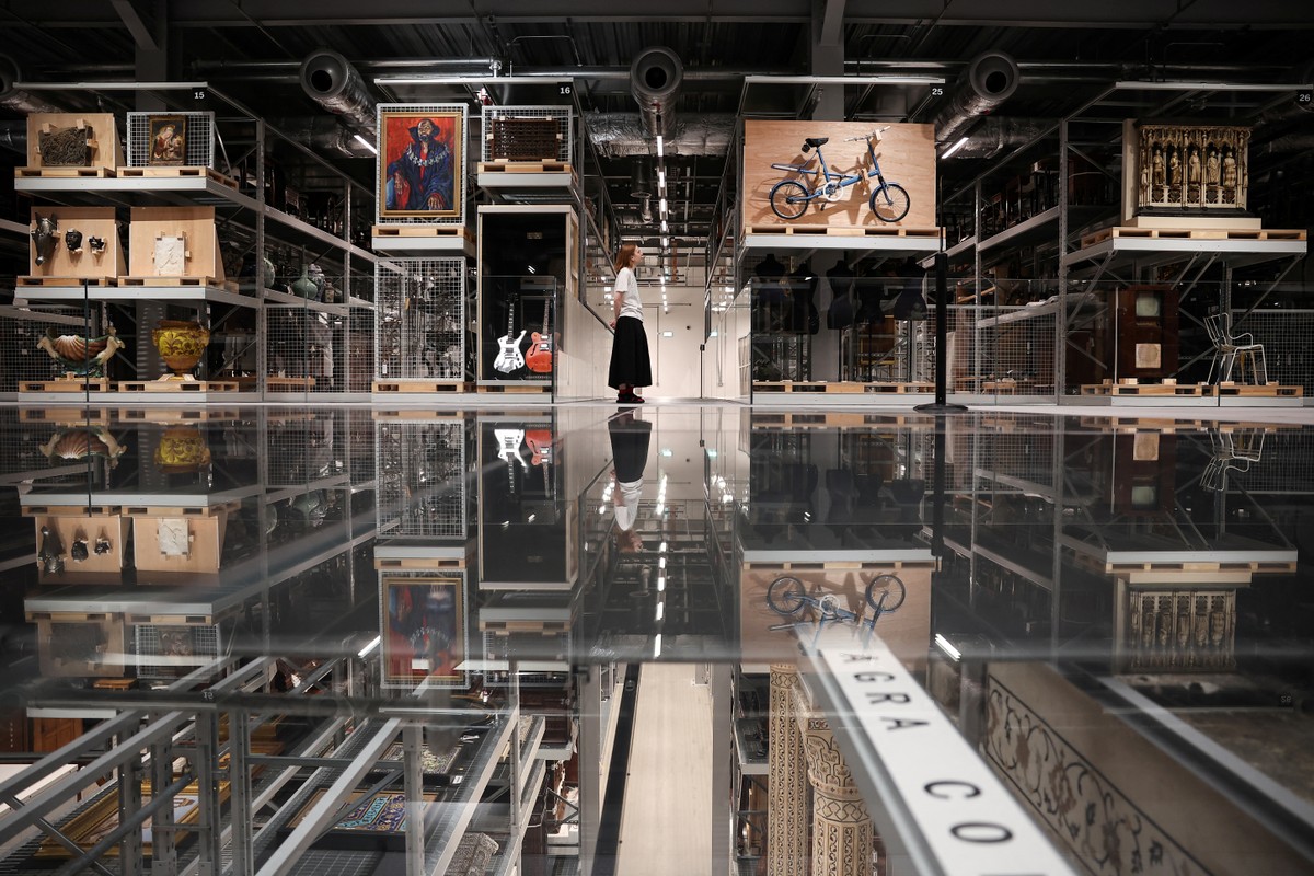 Museu de Londres disponibiliza depósito 'sob demanda' para visitação pública Um visitante observa os itens expostos no recém-inaugurado museu V&A East Storehouse, no leste de Londres, em 12 de junho de 2025. O V&A de Londres inaugurou um novo e revolucionário espaço expositivo, onde os visitantes podem escolher entre cerca de 250.000 objetos, encomendar algo que queiram admirar e recebê-lo em uma sala para uma visita privativa — Foto: Henry Nicholls / AFP