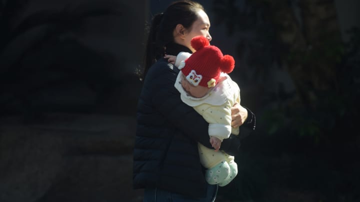 Beijing incentiva aumento da natalidade e empresas se preparam para pais da Gen Z Um pai caminha pela rua segurando uma criança em Hangzhou, China, em 17 de janeiro de 2025. (Foto: Costfoto | Nurphoto | Getty Images)
