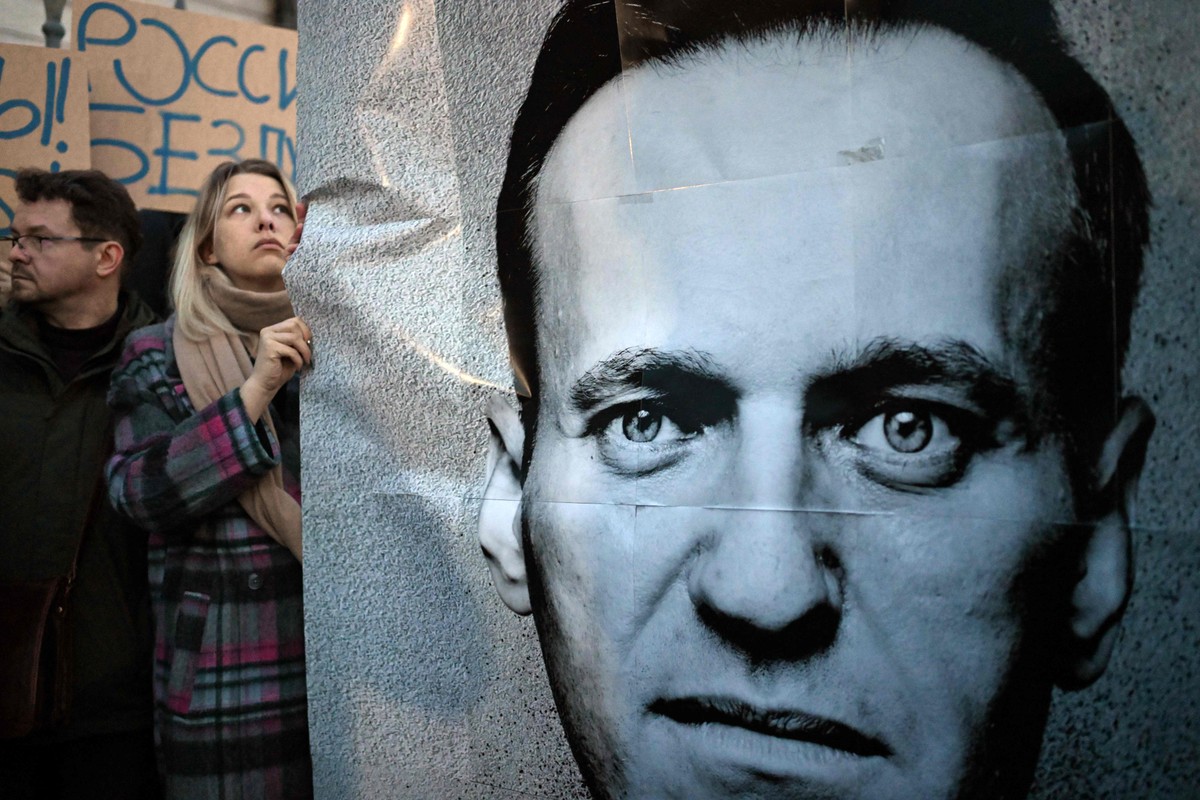 Manifestante segura imagem do oposicionista Alexey Navalny durante protesto em Varsóvia (Foto: Sergei GAPON / AFP)