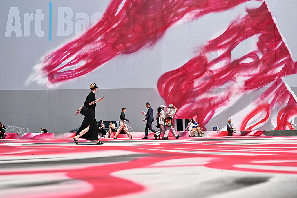 Visitantes caminham ao lado da obra de Katharina Grosse "CHOIR" 2025 exibida na Art Basel na Messe Basel em 17 de junho de 2025, em Basel, Suíça. (Foto: Harold Cunningham/Getty Images)