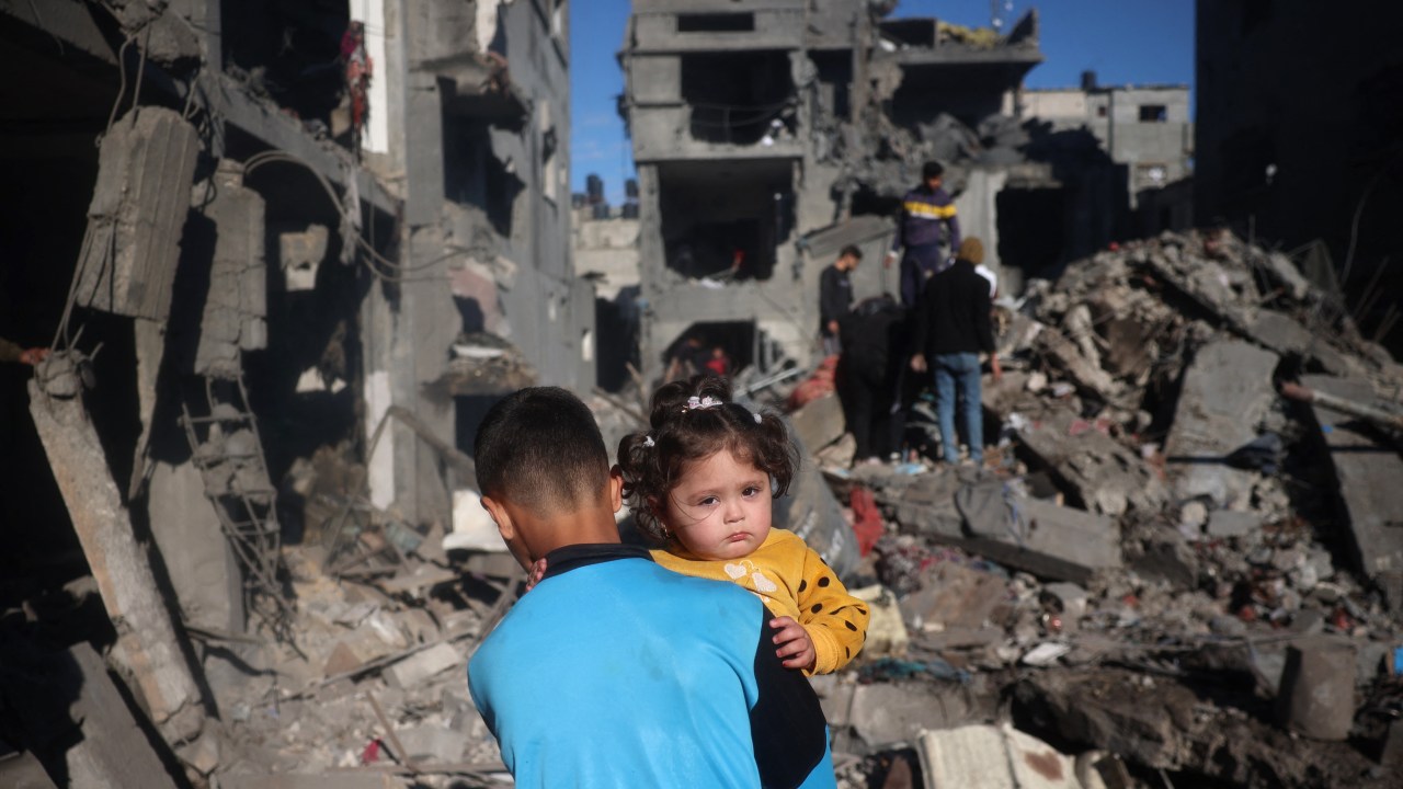 Crianças palestinas em meio aos escombros após novos ataques de Israel em Gaza - 23/03/2025 (Foto: Eyad BABA/AFP)