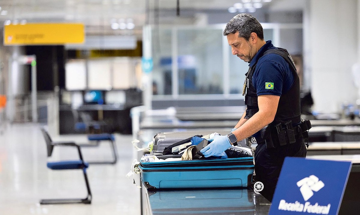 Trabalho de agente no Aeroporto de Guarulhos, de inspeção em malas (Foto: Maria Isabel Oliveira/ Agência O Globo)