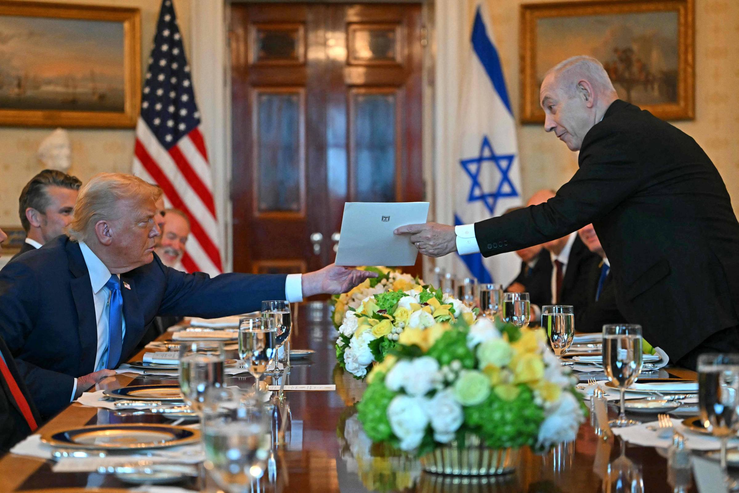 Premiê israelense Binyamin Netanyahu entrega carta ao presidente dos Estados Unidos, Donald Trump, durante encontro na Casa Branca, em Washington, DC (Foto: Andrew Caballero-Reynolds - 6.jul.25/AFP)
