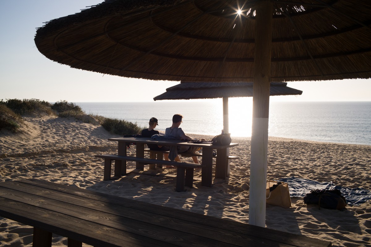Construtora portuguesa vende hotéis em meio a recordes de turismo no país Visitantes relaxam em uma praia próxima a Comporta, em Portugal (Foto: Goncalo Fonseca/Bloomberg)