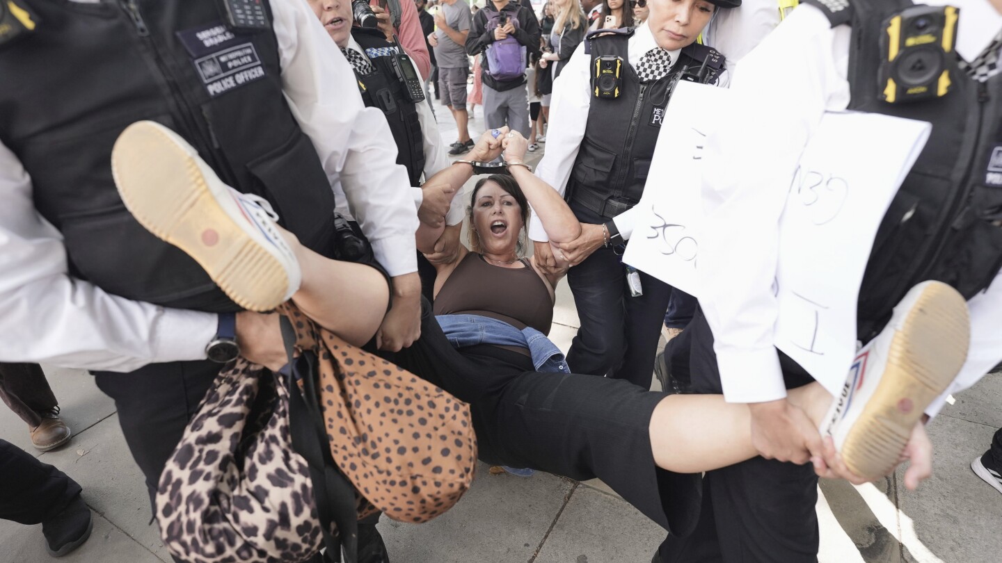 Uma mulher é levada por policiais enquanto apoiadores da Palestine Action participam de uma ação em massa na Parliament Square, organizada pelo Defend Our Juries como parte da campanha Lift the Ban, para acabar com a proscrição da Palestine Action, em Londres, no sábado, 9 de agosto de 2025. (Foto: Stefan Rousseau/PA via AP)