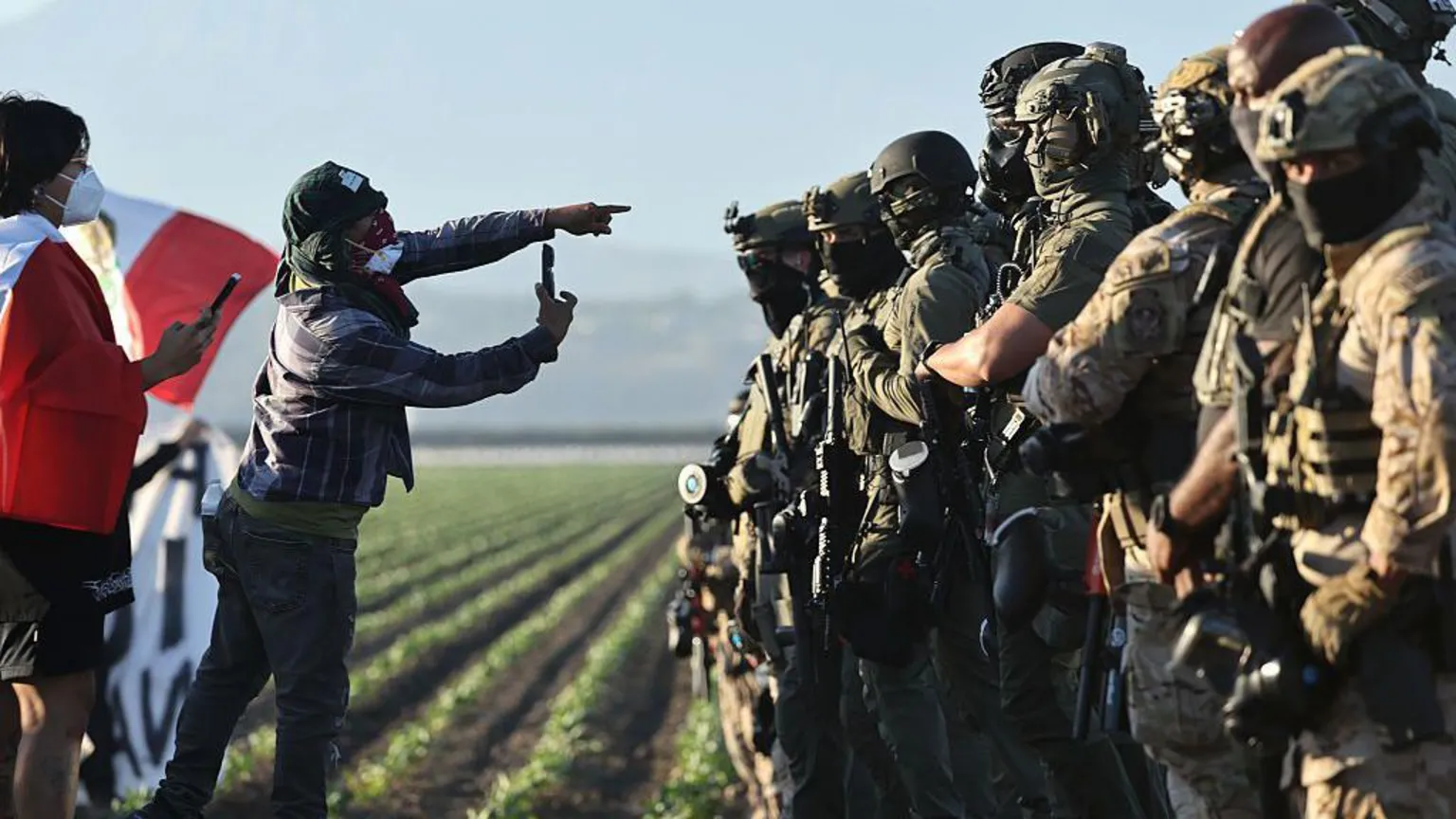Imigração intensa transforma cotidiano da Califórnia e gera incertezas sociais Protestantes filmam oficiais federais na zona rural do sul da Califórnia - Foto: Getty Images