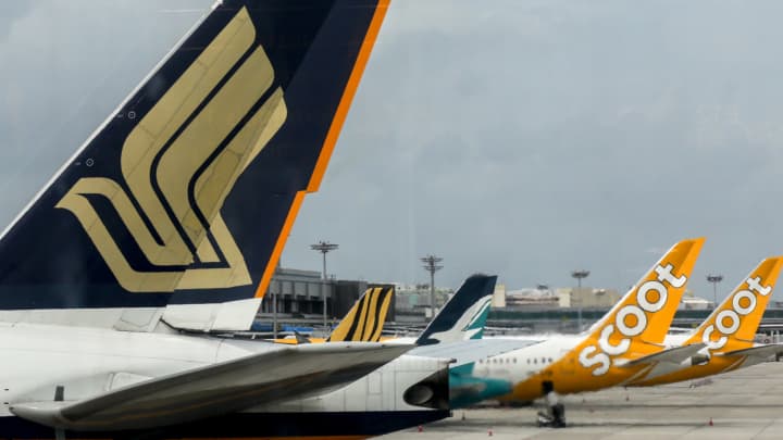 Ações da Singapore Airlines despencam mais de 8% após queda acentuada no lucro do primeiro trimestre Aviões de passageiros civis da Singapore Airlines e suas subsidiárias — Tigerair, Silkair e Scoot — no Aeroporto Internacional de Changi, Singapura. (Foto: Universal Images Group | Getty Images)