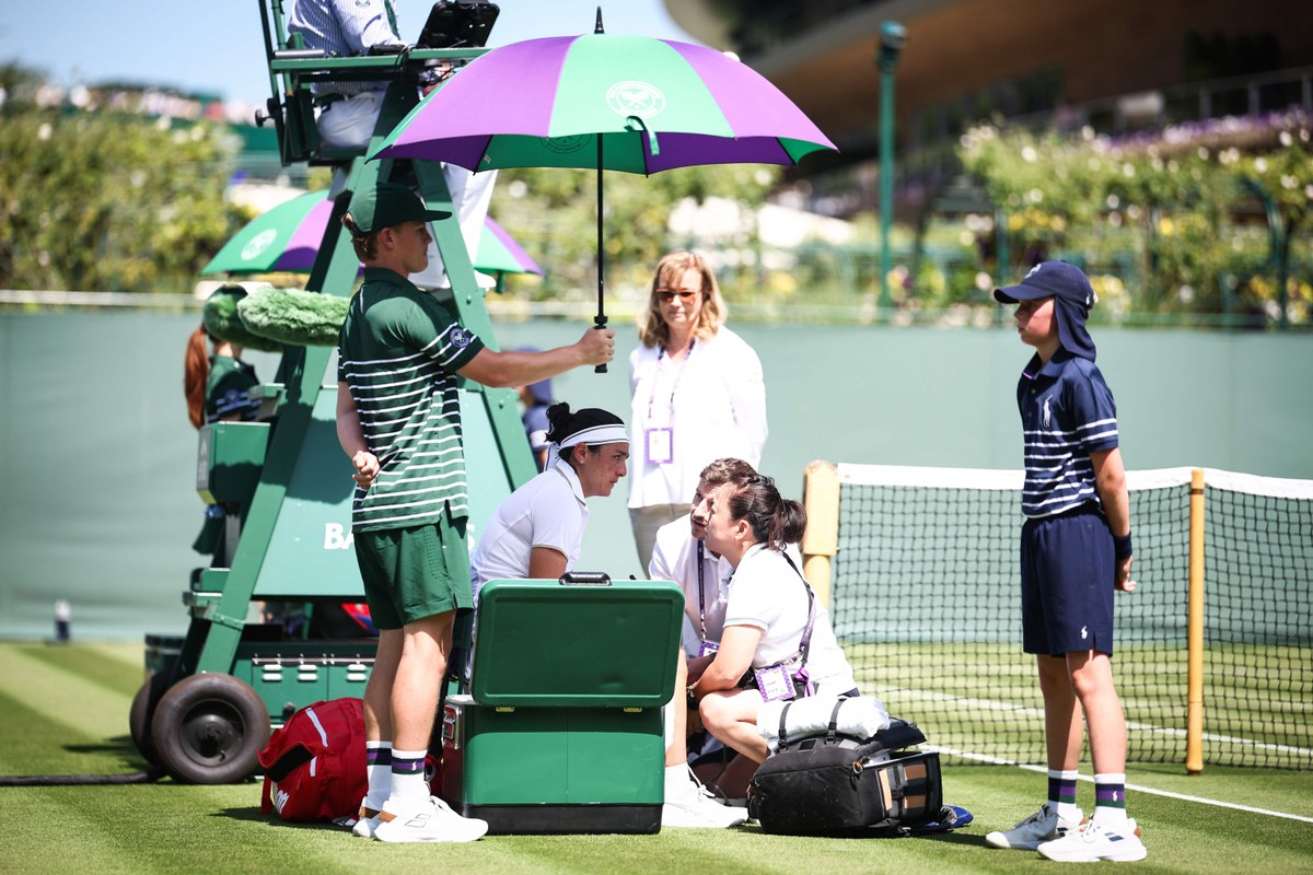 Ons Jabour enxuga lágrimas após perder longo quinto game no primeiro set e ficou longo tempo fora da quadra por motivos médicos (Foto: Henry Nicholls/AFP).