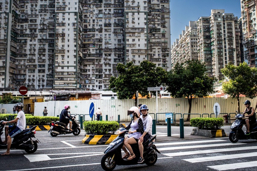 Pessoas andam de moto em um cruzamento movimentado de Macau (Foto: Chris McGrath/Getty Images)