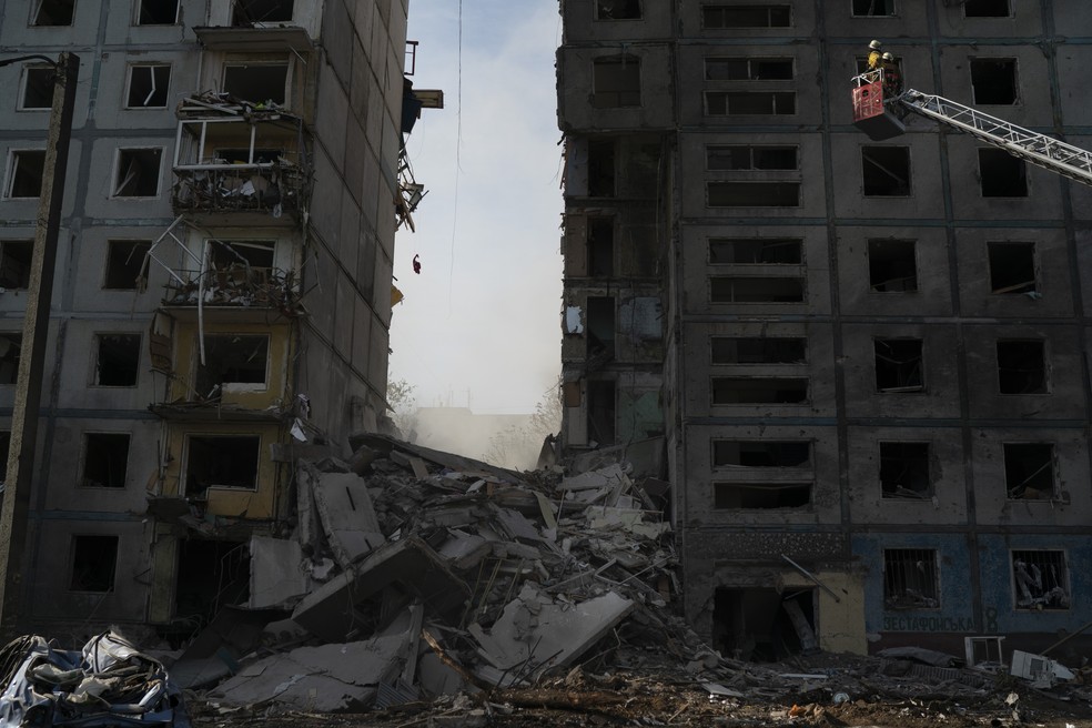 Rússia ataca penitenciária na Ucrânia e provoca 17 mortes Bombeiros trabalham nos escombros de um edifício residencial que foi danificado após um ataque russo em Zaporizhzhia, na Ucrânia. (Foto: AP Photo/Leo Correa)