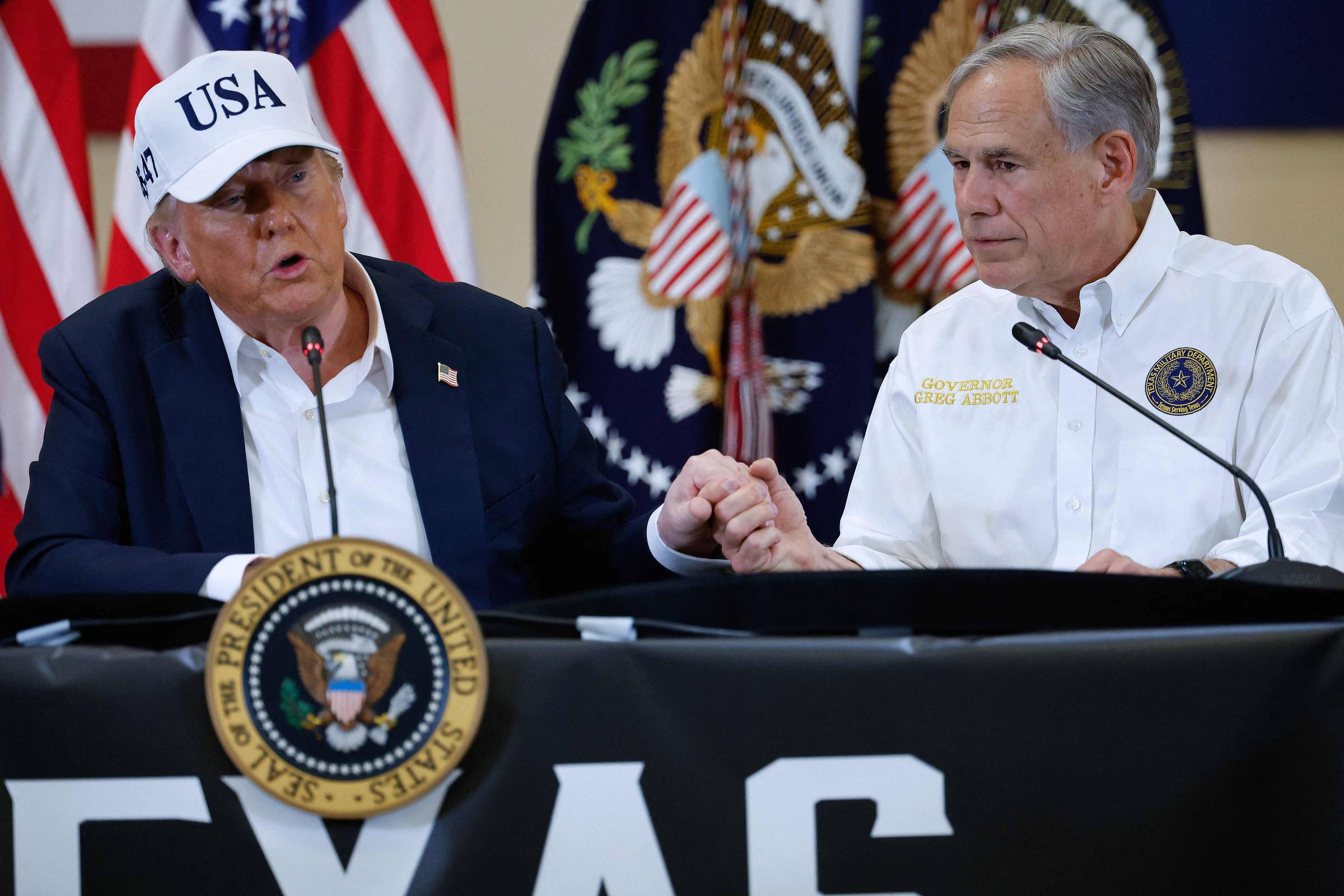 O presidente dos Estados Unidos, Donald Trump, com o governador do Texas, Greg Abbott, em entrevista após as enchentes no estado (Foto: Chip Somodevilla - 11.jul.25/Getty Images via AFP)