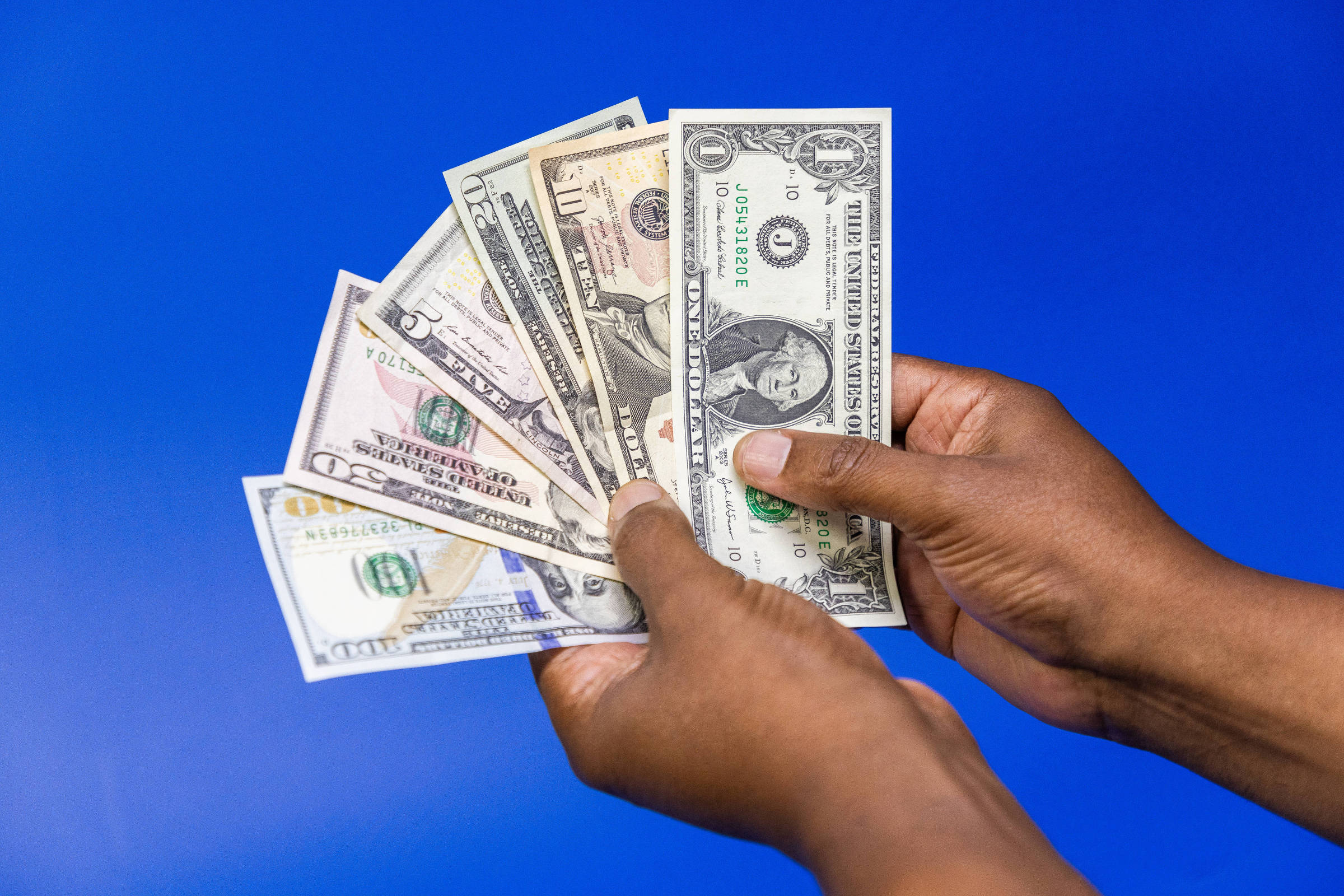 Pessoa segura notas de dólar (Foto: Pedro Affonso - 18.dez.2024/Folhapress)