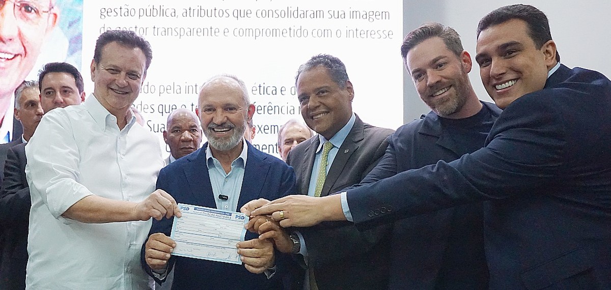 Paulo Hartung segura ficha de filiação ao PSD, ao lado de Gilberto Kassab (esq) (Foto: Eduardo Mattos/PSD)
