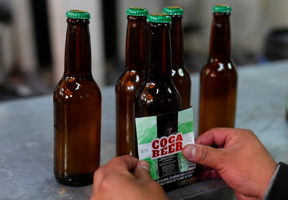 Coca conquista novos espaços urbanos e desafia sua imagem ancestral Botellas de cerveza con sabor a hoja de coca en un local en La Paz, Bolivia, en 2024. (Foto: Juan Karita/AP)