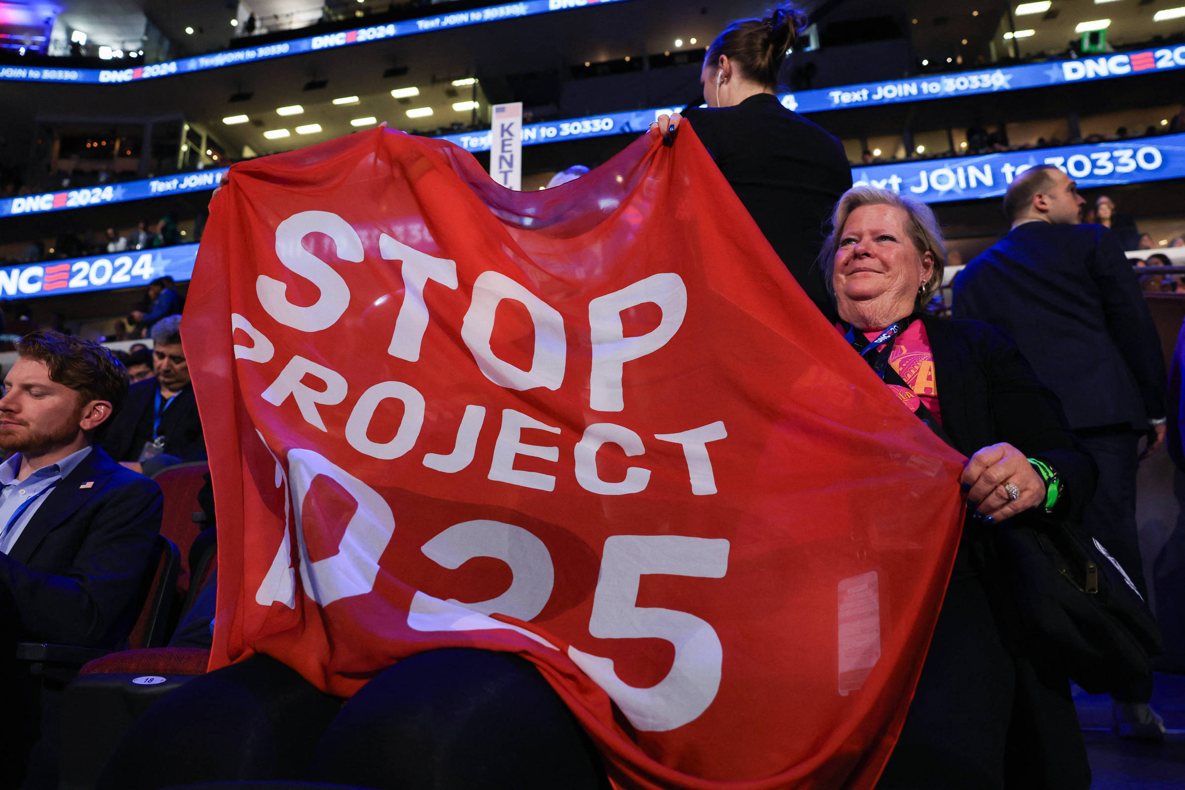 Democratas adotam estratégia republicana com o 'Projeto 2029' contra Trump Pessoa segura uma bandeira com os dizeres "Parem o Projeto 2025" durante a Convenção Nacional Democrata em Chicago, nos EUA, em 2024 (Foto: Kevin Wurm - 20.ago.2024/Reuters)