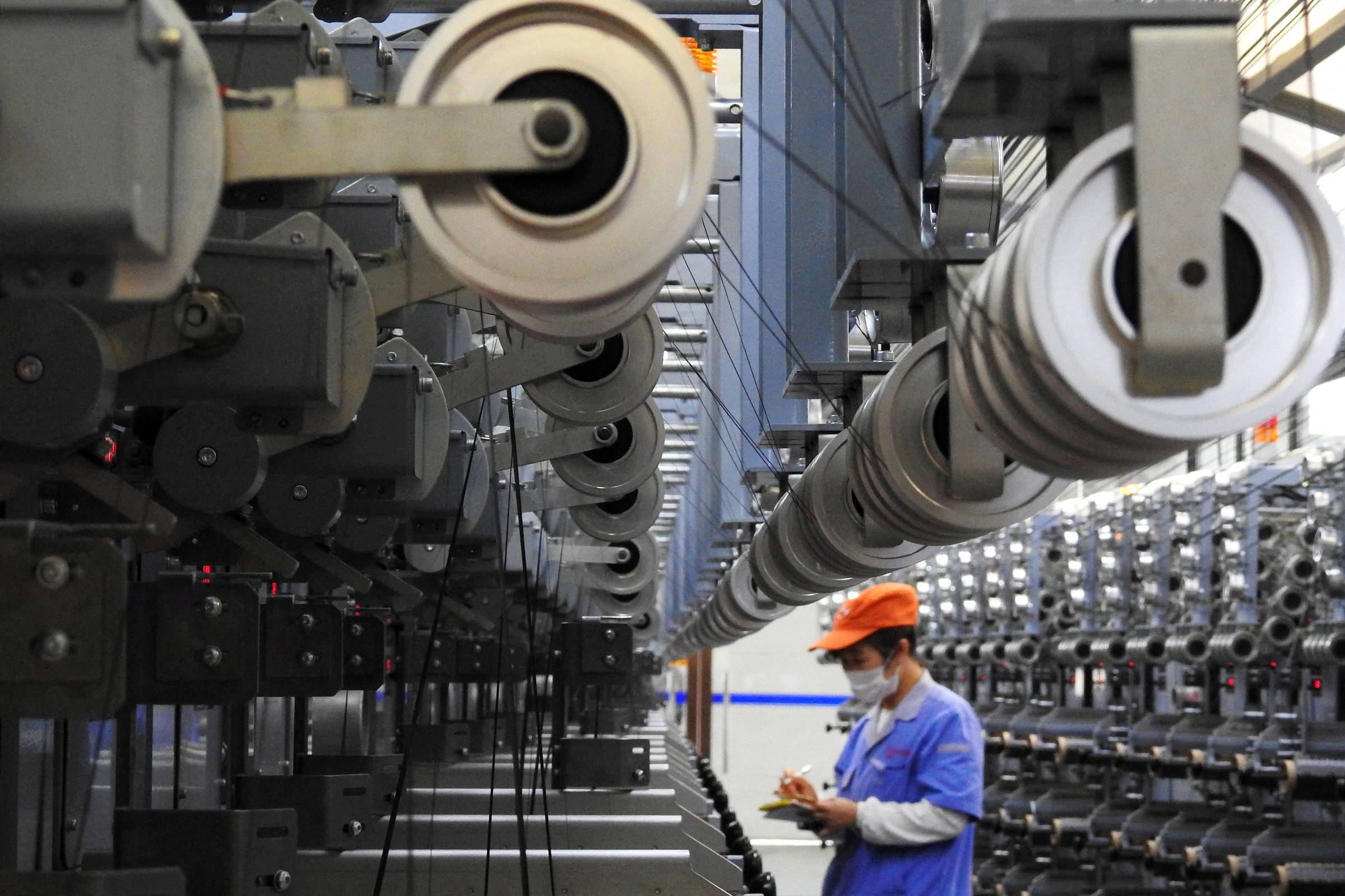 Profissional trabalha na linha de produção de uma fábrica no interior da China (Foto: CHINA STRINGER NETWORK - 27.out.18/Reuters)