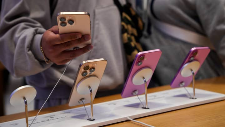 Pessoas olham para iPhones na loja da Apple Fifth Avenue em Nova York no dia 23 de maio de 2025. (Foto: Adam Gray | Reuters)