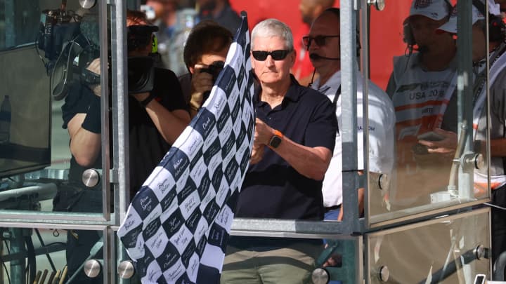 Apple conquista vitória significativa com 'F1', mas enfrenta desafios com IA Tim Cook acena a bandeira quadriculada para o vencedor da corrida, Max Verstappen, da Red Bull. (Foto: Mike Segar | Reuters)