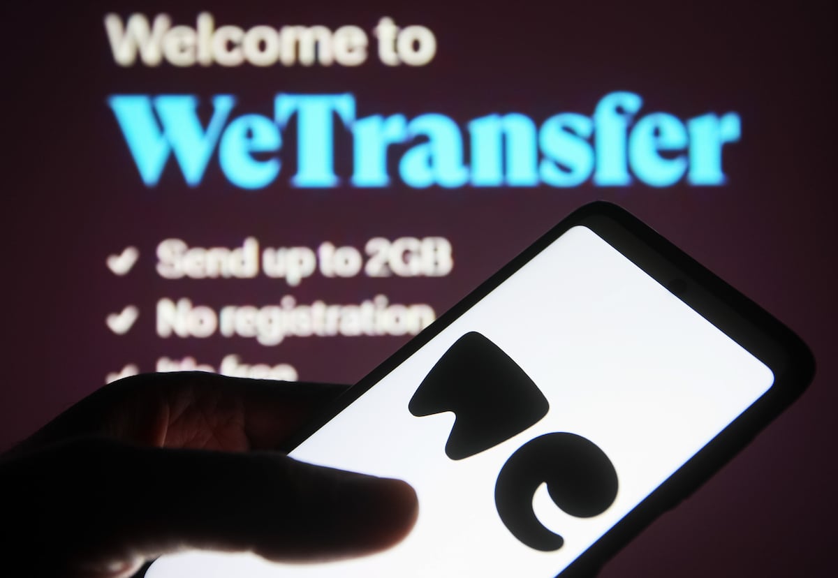 WeTransfer usará documentos de usuários para treinar inteligência artificial Um usuário maneja seu telefone frente a uma tela com o serviço WeTransfer aberto. (Foto: SOPA Images/SOPA Images/LightRocket via Getty Images)