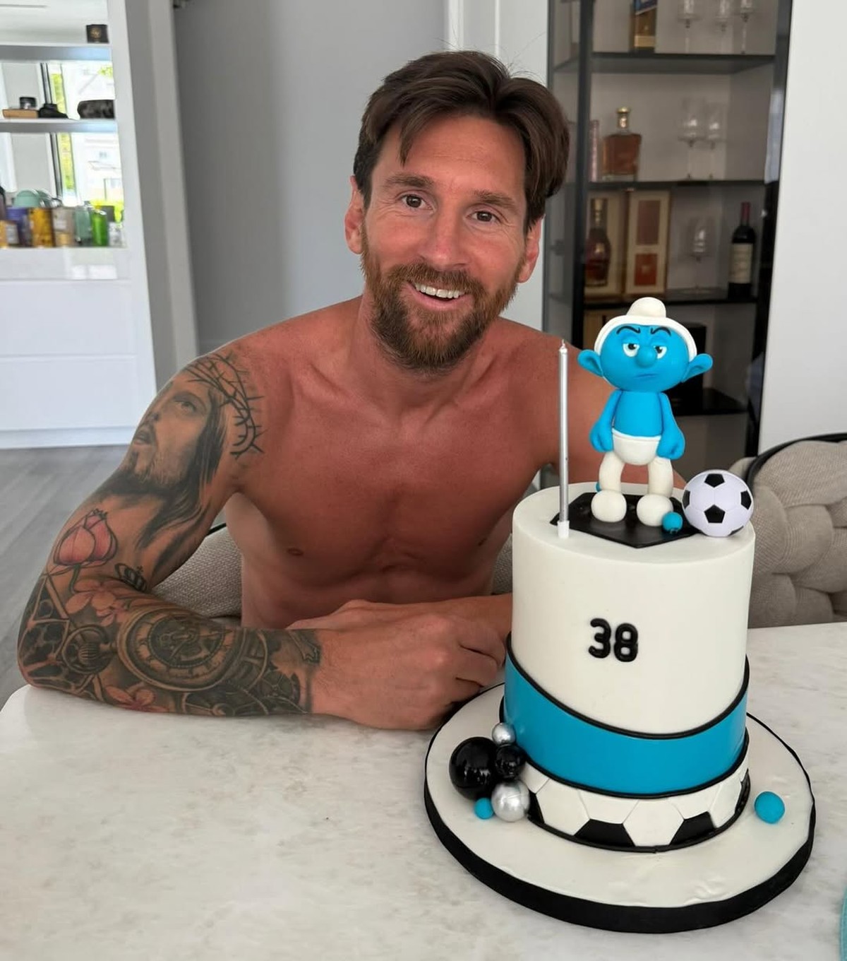 Messi celebra 38 anos com bolo temático dos 'Smurfs' em festa especial Lionel Messi com bolo de aniversário (Foto: Reprodução)