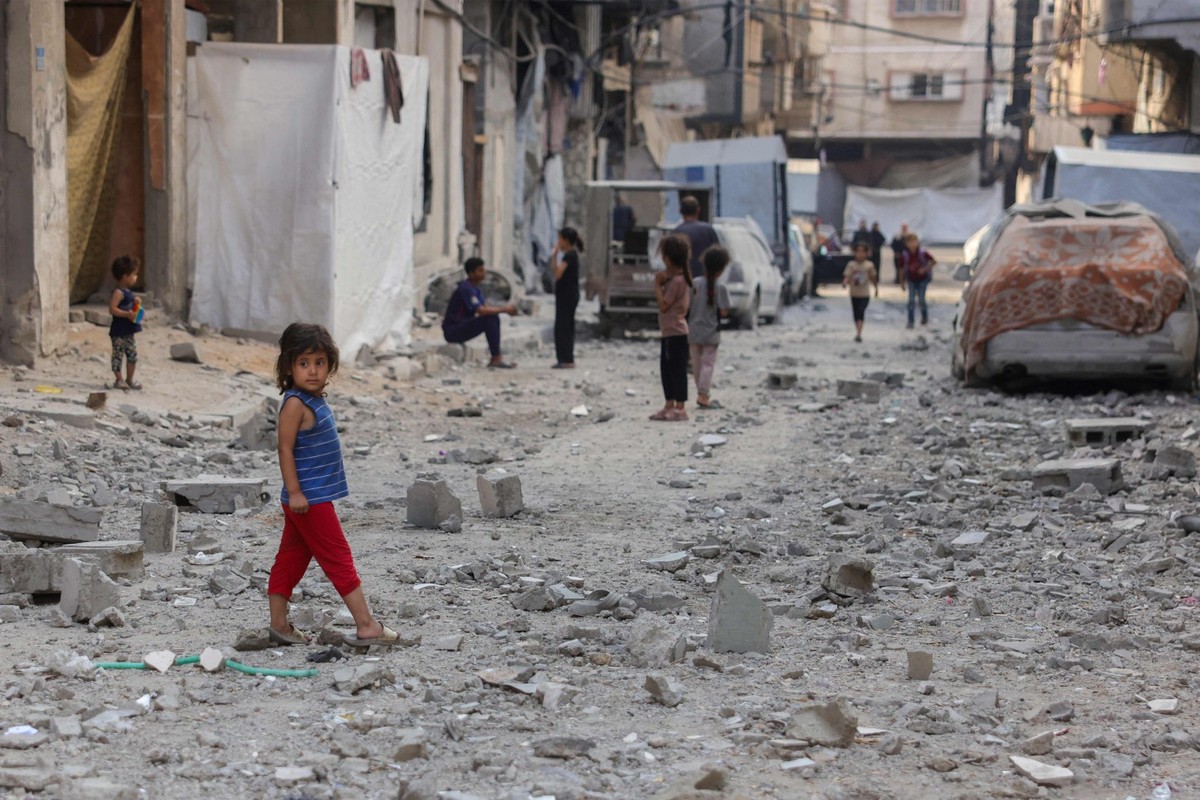 Israel negocia com o Catar apesar das exigências do Hamas para cessar-fogo Crianças palestinas caminham em ruas cobertas por escombros de edifício atingido por ataque israelense na cidade de Gaza (Foto: Bashar TALEB / AFP)