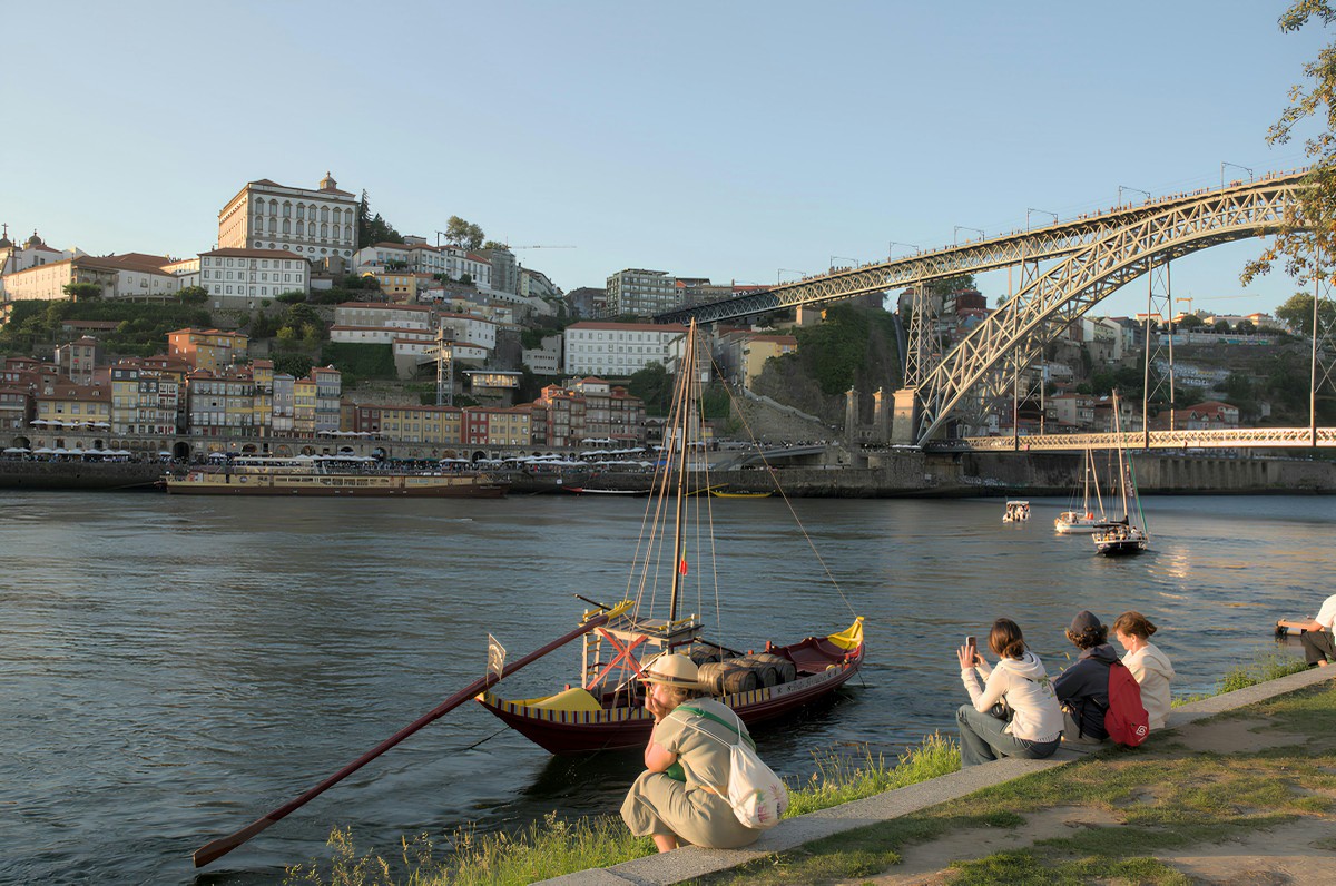 Porto impõe restrições à venda de bebidas alcoólicas durante a noite Turistas às margens do Rio Douro, no Porto: cidade no norte de Portugal tem nova 'lei seca' que dificulta venda de bebidas alcóolicas à noite (Foto: Tayan Lima/Reprodução/Unslpash)