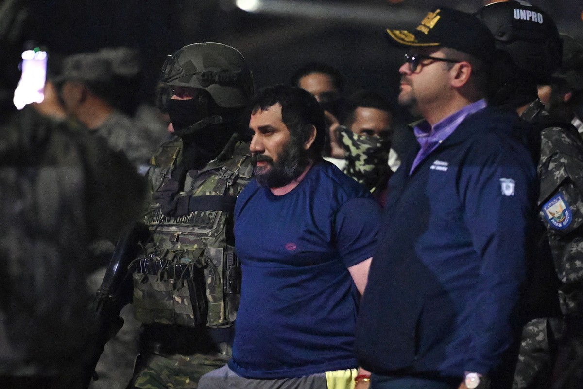 Chefe da organização criminosa Los Choneros, José Adolfo Macías Villamar, o Fito, é acompanhado por policiais equatorianos após sua captura (Foto: Marcos PIN / AFP).