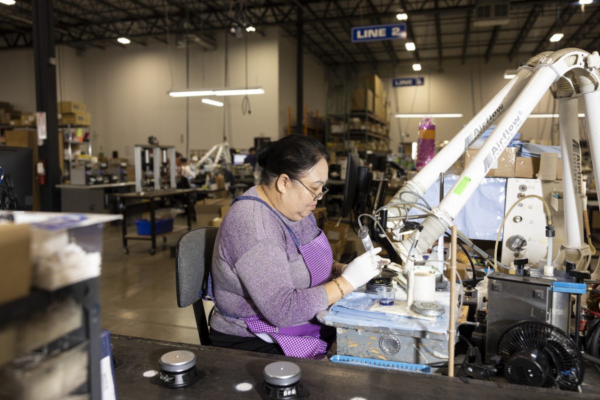 Funcionária monta alto-falantes na fábrica da MISCO, em Minnesota, nos Estados Unidos (Foto: Jenn Ackerman/The New York Times)