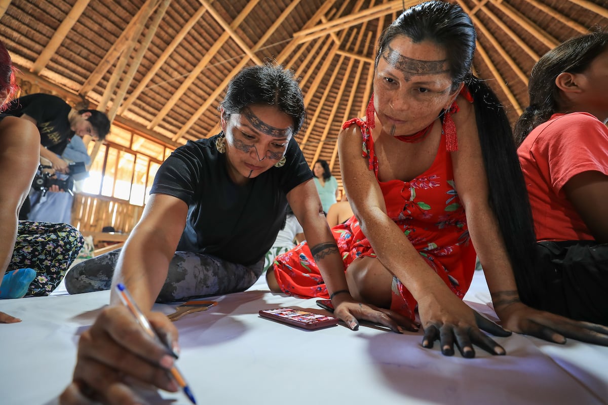 Um grupo de mulheres indígenas pinta um telar na selva de Sarayaku, Equador, em 28 de junho de 2025 (Foto: JOSÉ JÁCOME/EFE)