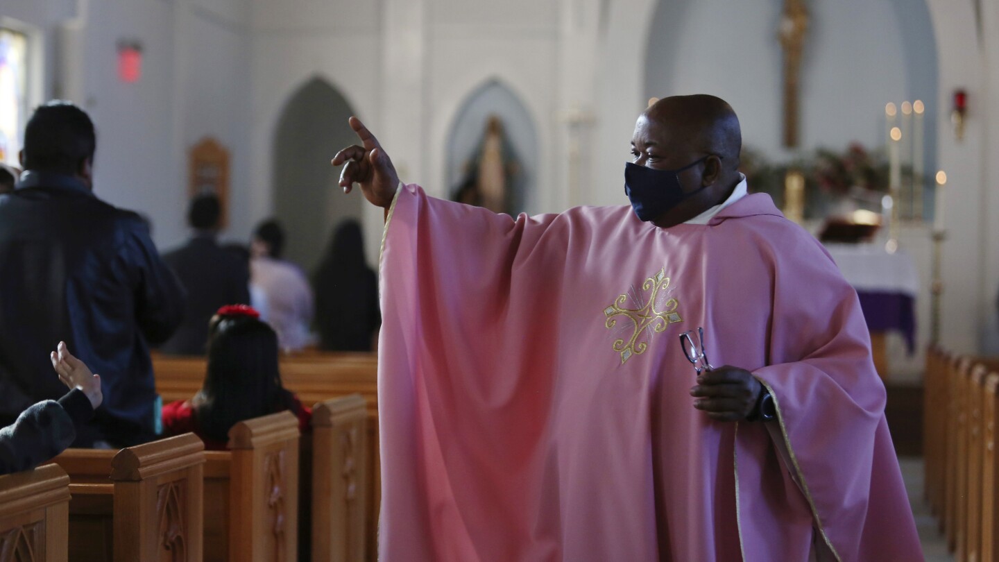 O Rev. Athanasius Abanulo acena para seus paroquianos após a Missa em 12 de dezembro de 2021, na Igreja Católica Imaculada Conceição em Wedowee, Alabama. (Foto: AP Photo/Jessie Wardarski, File)