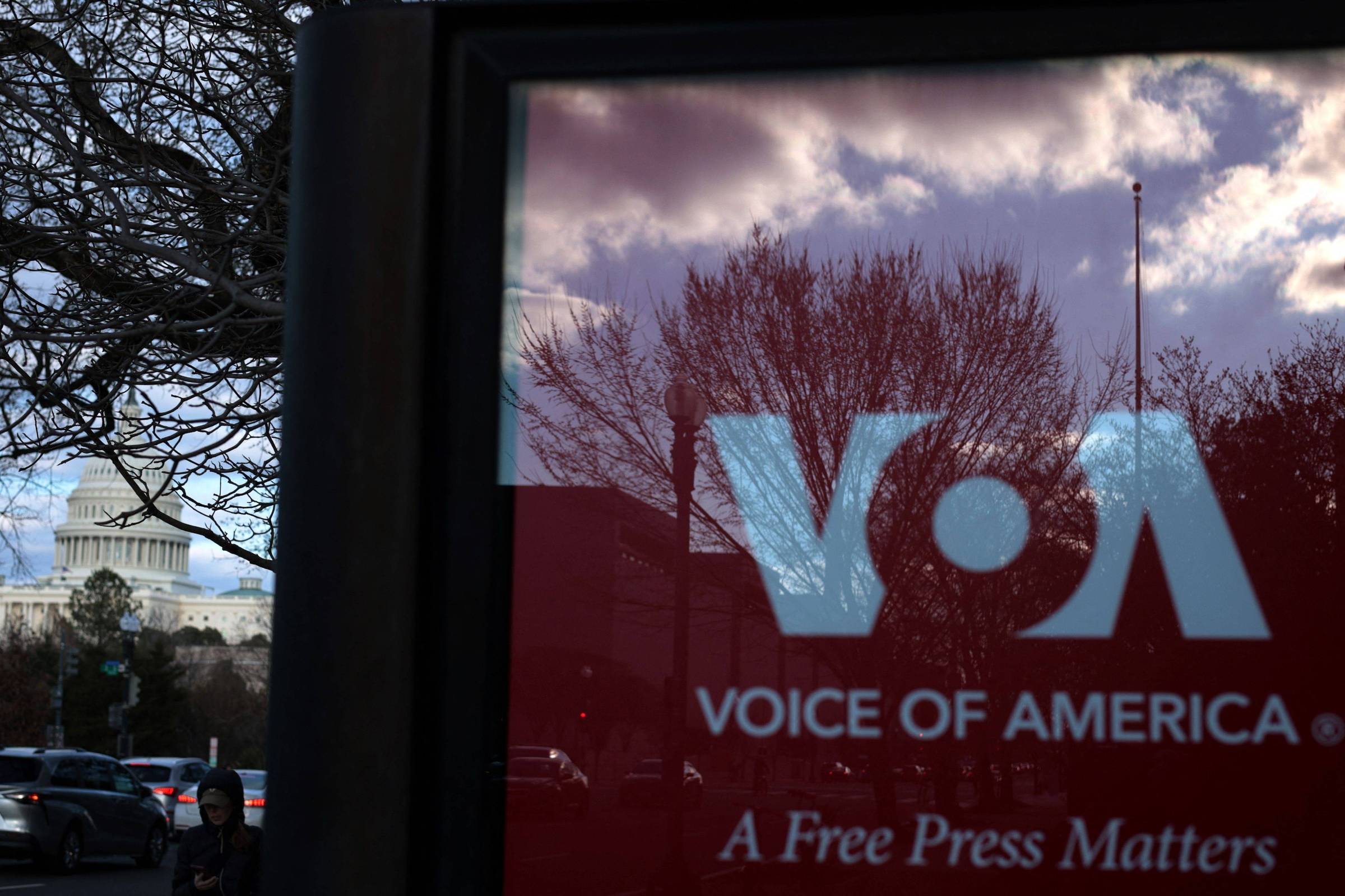 Rivais aproveitam desmantelamento da Voz da América nos Estados Unidos Placa de propaganda do programa Voice of America (VOA) em ponto de ônibus de Washington, EUA; ao fundo, Capitólio (Foto: ALEX WONG/Getty Images via AFP)