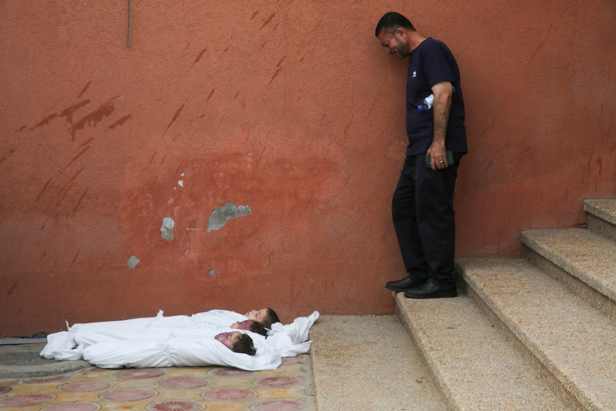 Um homem chora ante os cadáveres de três crianças mortas em um ataque israelense no hospital Nasser de Jan Yunis, nesta quinta-feira. (Foto: Hatem Khaled/REUTERS)