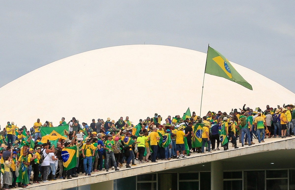 Apoiadores do ex-presidente brasileiro Jair Bolsonaro invadem o Congresso Nacional em Brasília em 8 de janeiro de 2023. Centenas de apoiadores do ex-presidente de extrema direita Jair Bolsonaro romperam as barricadas policiais e invadiram o Congresso, o palácio presidencial e o Supremo Tribunal no domingo, em um protesto dramático contra a posse do presidente Luiz Inácio Lula da Silva na semana passada — Foto: Sergio Lima / AFP