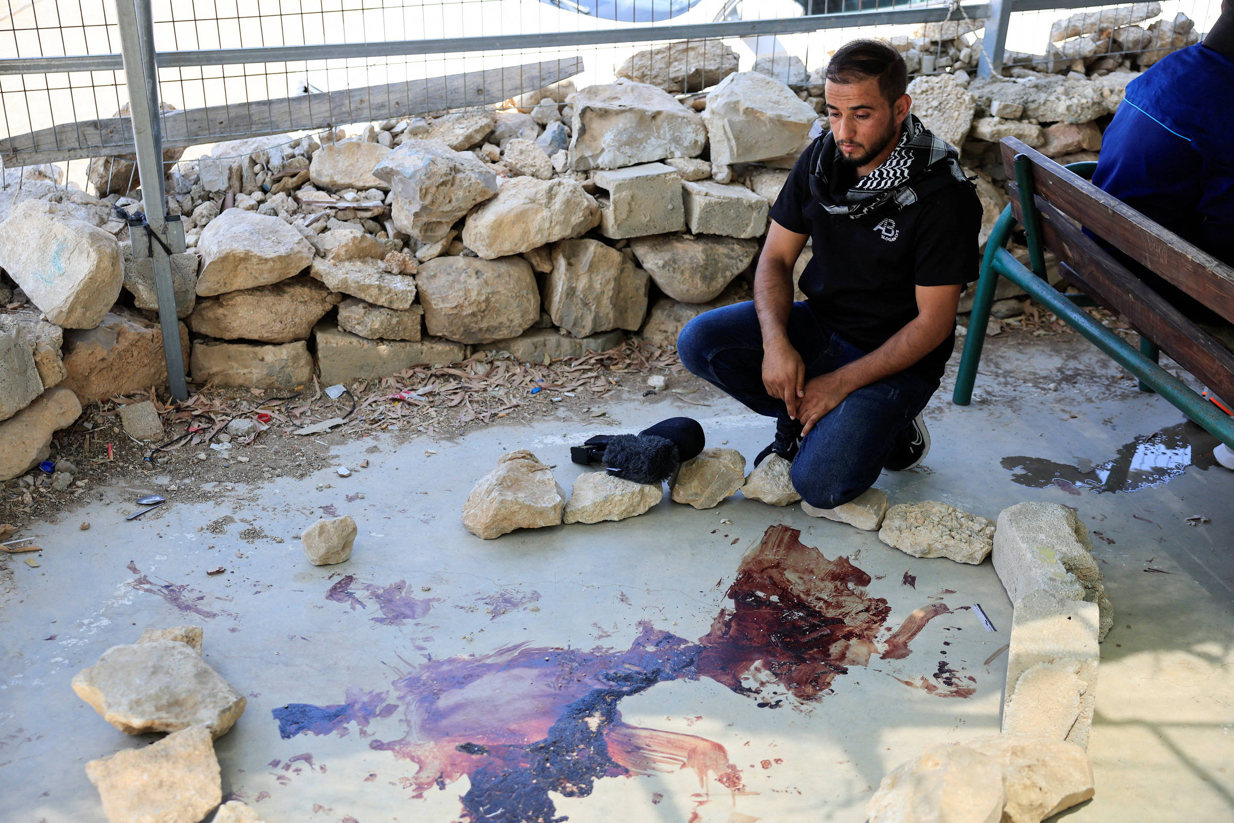 Israel solta colono acusado de assassinar palestino que colaborou com filme premiado Homem em frente a mancha de sangue após colono israelense atirar em palestinos e matar colaborador de filme vencedor do Oscar (Foto: Mussa Qawasma/Reuters)