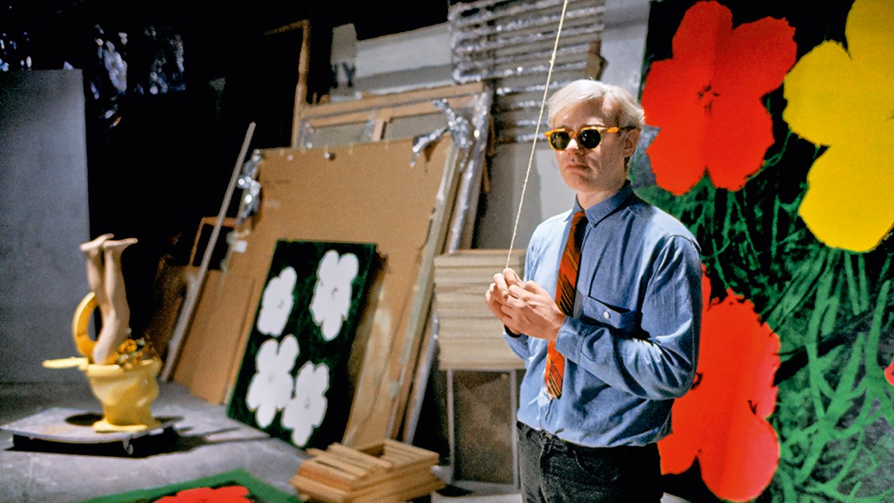 A vida complexa e controversa de Andy Warhol revela o ser humano por trás da arte Observador calado - Warhol em seu ateliê na lendária Factory, em Nova York: timidez e insegurança sobre sua obra (Foto: Bob Adelman Estate/.)